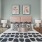  A bedroom with a pink headboard and two framed pictures above it.