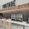  A vintage themed bar with a counter and a sign above it.