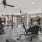  A spacious gym with a variety of equipment and a ceiling fan.