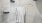  A white robe is hanging on a hanger in a closet.