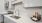  A modern kitchen with a white countertop and a stainless steel sink.
