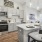  A modern kitchen with a white island and stainless steel appliances.
