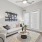  A living room with a grey couch, a coffee table, and a painting on the wall.