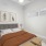  A bedroom with a bed, nightstand, and two framed plants on the wall.